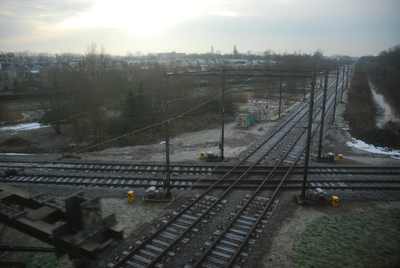 904548 Gezicht op de spoorkruising te Blauwkapel bij Utrecht, vanuit een trein over het naastgelegen viaduct. Van links ...
